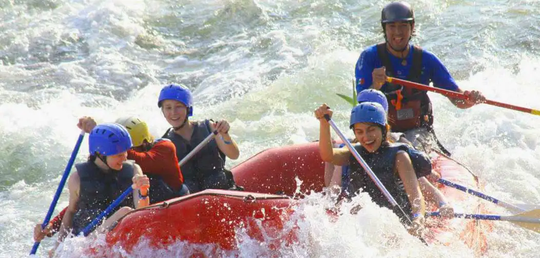 Un balsa con chicas sonriendo mientras practican rafting