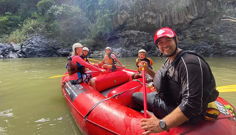 Un grupo sonriendo a la cámara sobre una balsa roja en el río Amacuzac